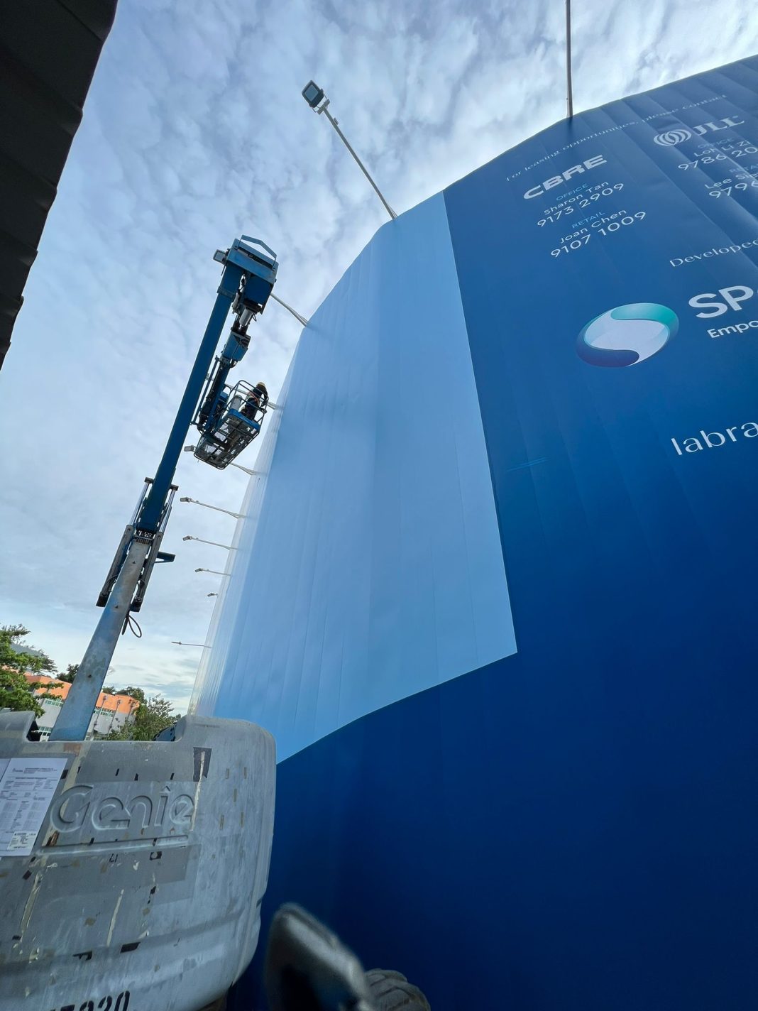 Labrador Tower construction hoarding with boomlift